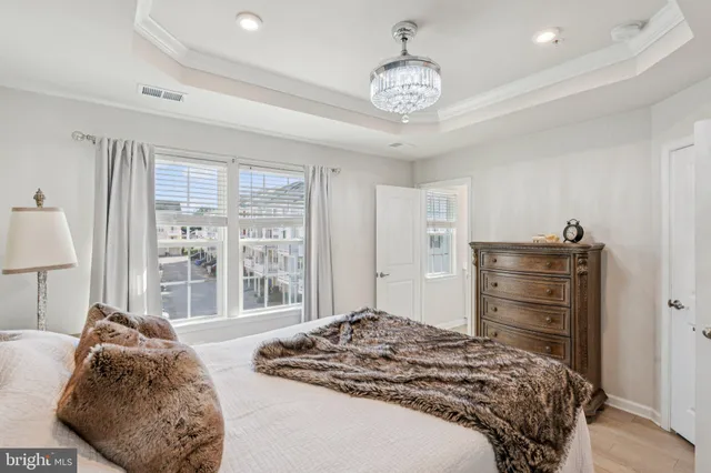a bedroom with a large bed and a chandelier
