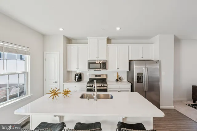 a kitchen with stainless steel appliances a refrigerator and a stove top oven