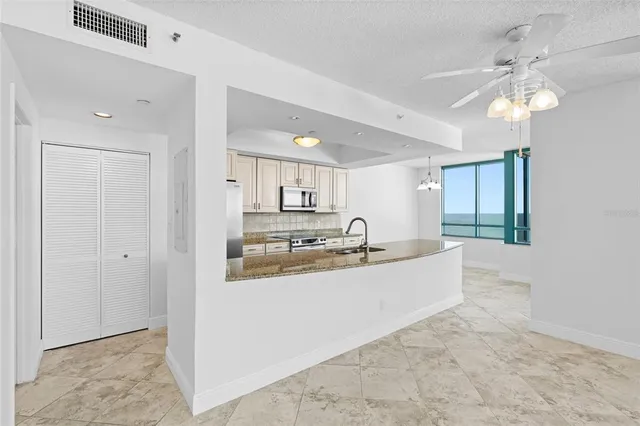 a kitchen with stainless steel appliances granite countertop a sink a stove and a refrigerator