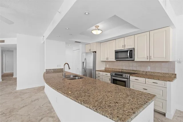 a large white room with a large window and kitchen