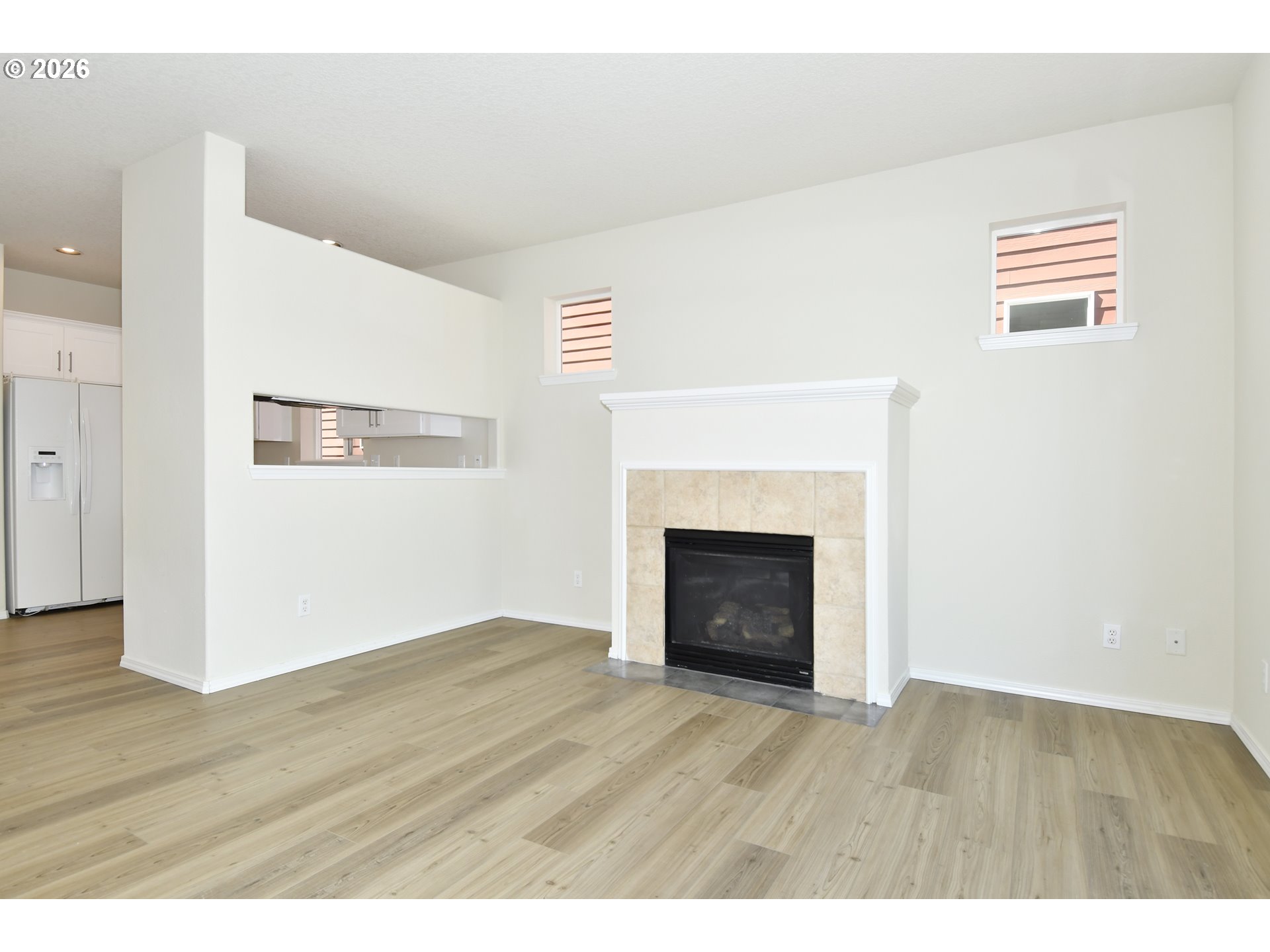 20477 Southwest Marimar Street Beaverton, OR 97078 - Photo 11 of 28 a view of empty room with wooden floor and fireplace