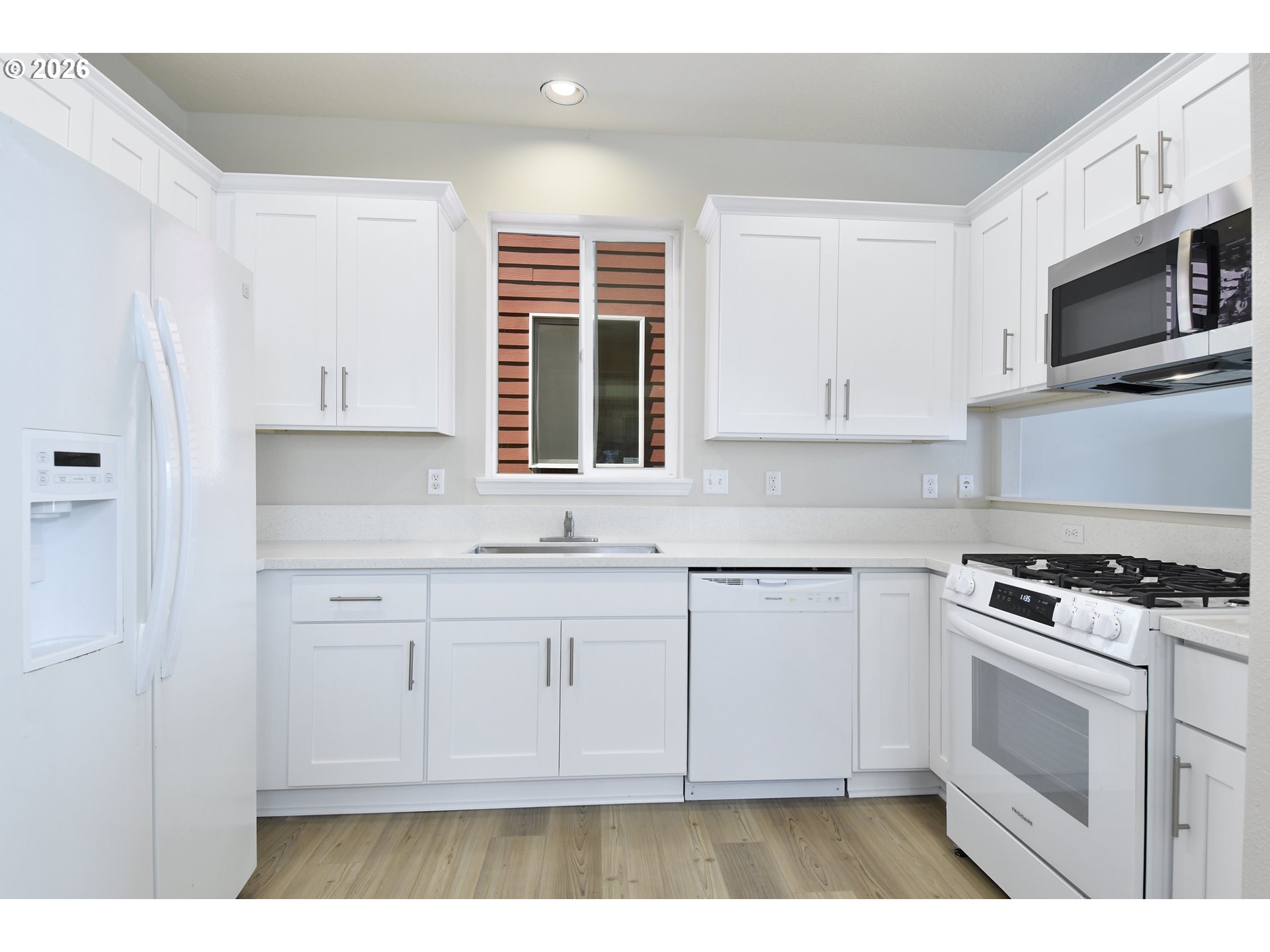 20477 Southwest Marimar Street Beaverton, OR 97078 - Photo 13 of 28 a kitchen with stainless steel appliances white cabinets and a stove top oven