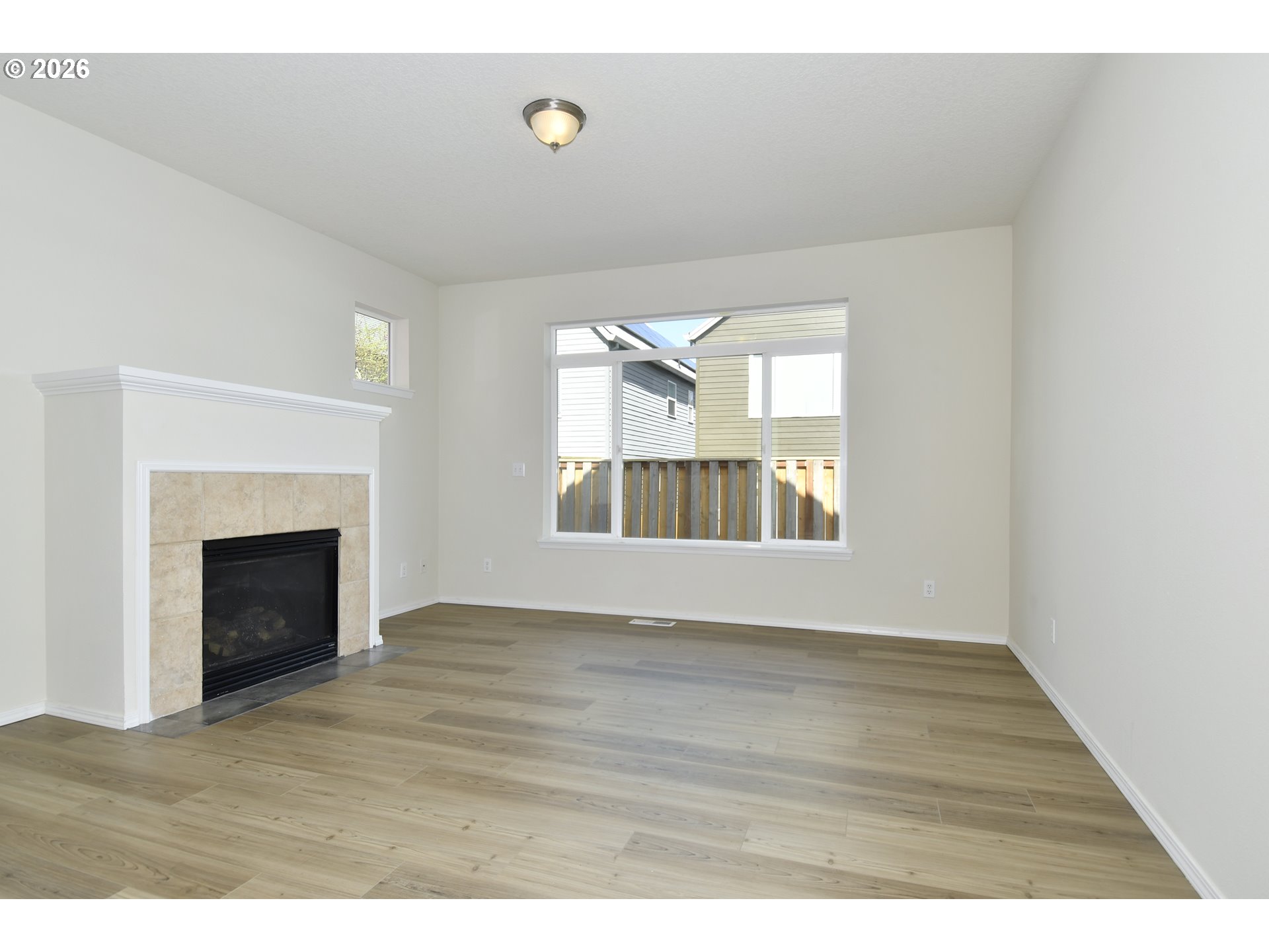 20477 Southwest Marimar Street Beaverton, OR 97078 - Photo 5 of 28 a view of an empty room with a fireplace and wooden floor