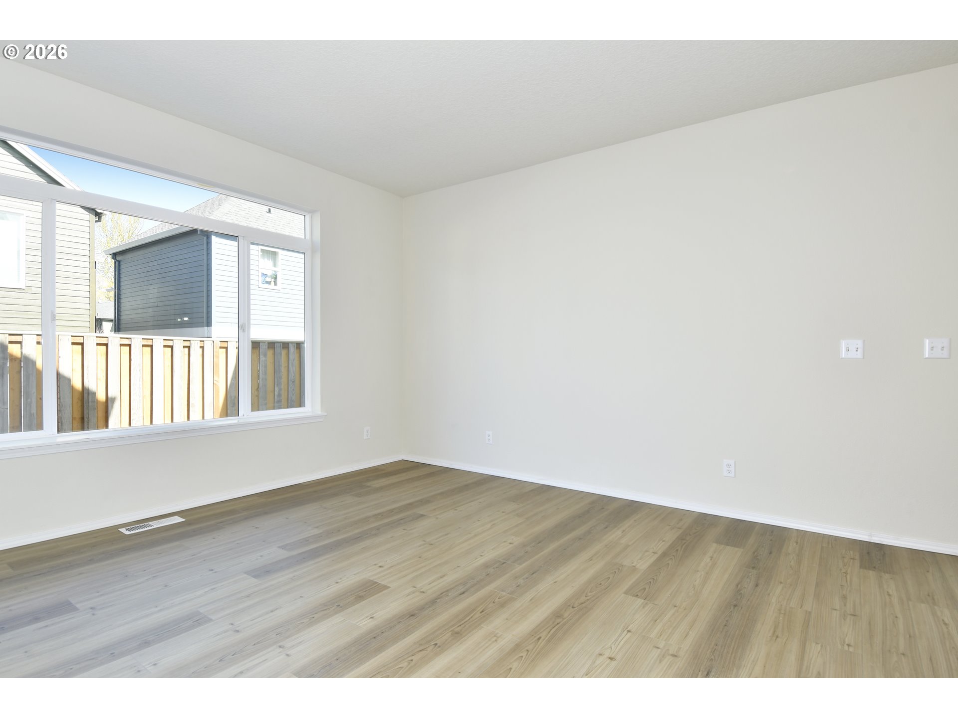 20477 Southwest Marimar Street Beaverton, OR 97078 - Photo 7 of 28 a view of an empty room with wooden floor and a window