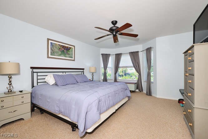 20012 Heatherstone Way, Unit 1 Estero, FL 33928 - Photo 19 of 48 a bedroom with a large bed and a chandelier