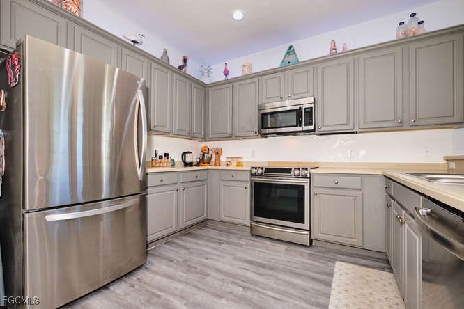 20012 Heatherstone Way, Unit 1 Estero, FL 33928 - Photo 8 of 48 a kitchen with granite countertop a refrigerator stove and microwave