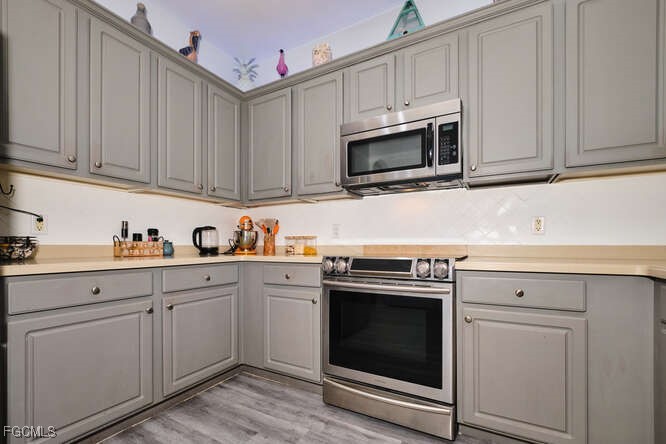 20012 Heatherstone Way, Unit 1 Estero, FL 33928 - Photo 9 of 48 a kitchen with white cabinets stainless steel appliances and sink