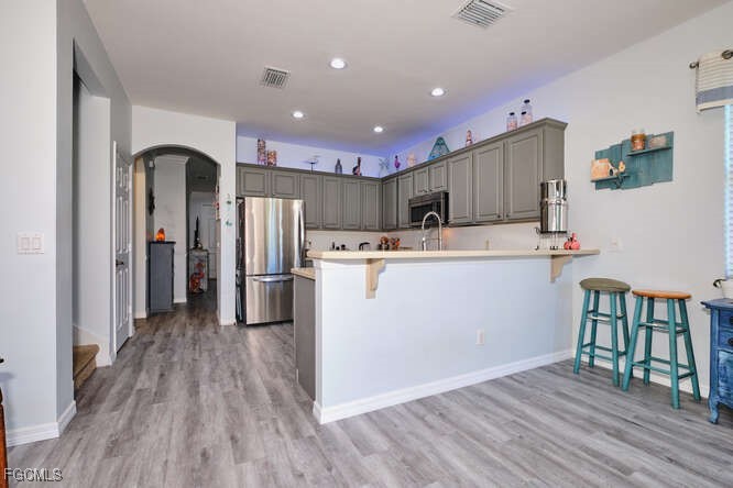 20012 Heatherstone Way, Unit 1 Estero, FL 33928 - Photo 10 of 48 a kitchen with stainless steel appliances granite countertop a refrigerator a stove top oven and a sink with wooden floor