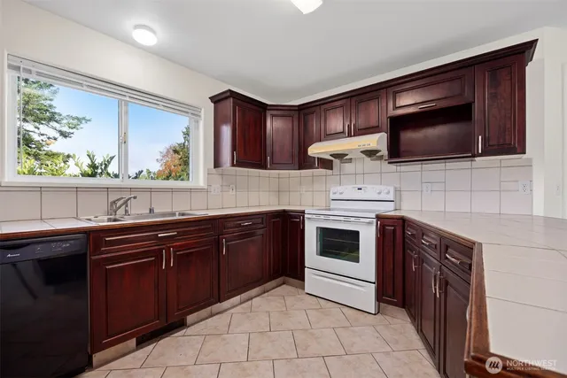 a kitchen with a sink a refrigerator and a stove top oven