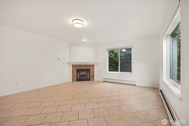 a view of an empty room with a fireplace and a window