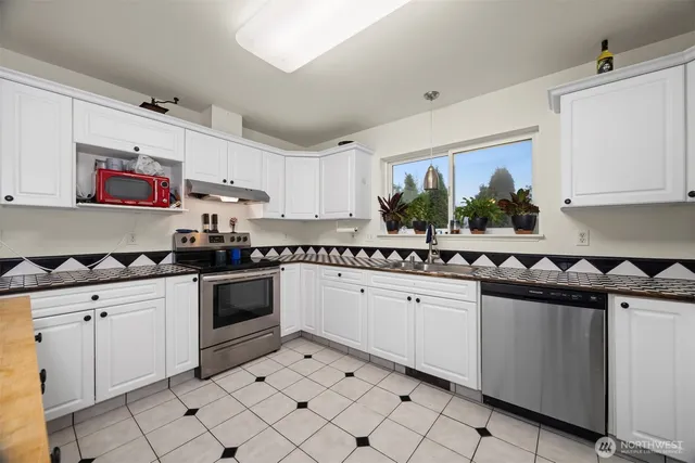 a kitchen with granite countertop white cabinets and white appliances