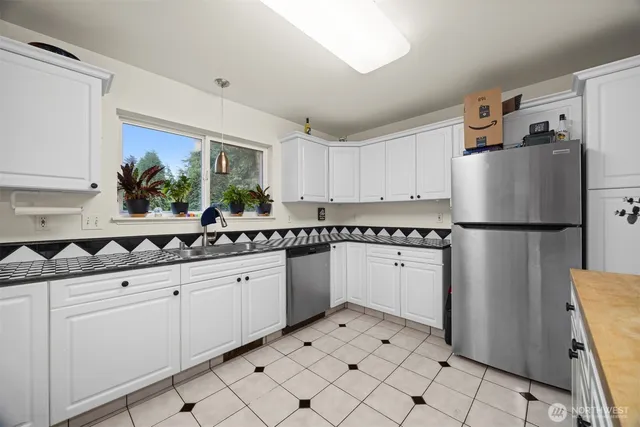 a kitchen with stainless steel appliances a refrigerator sink and cabinets