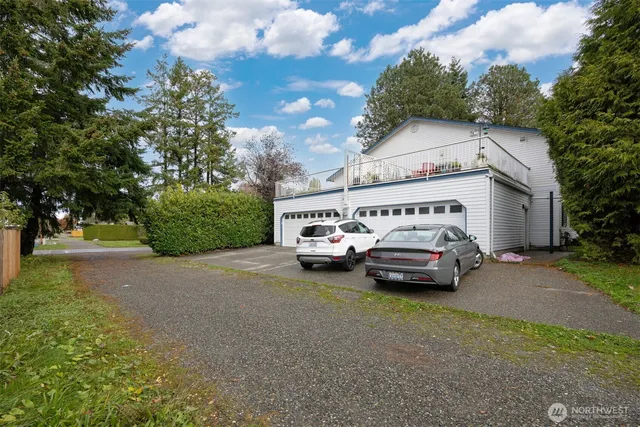 a white house covered with tall trees
