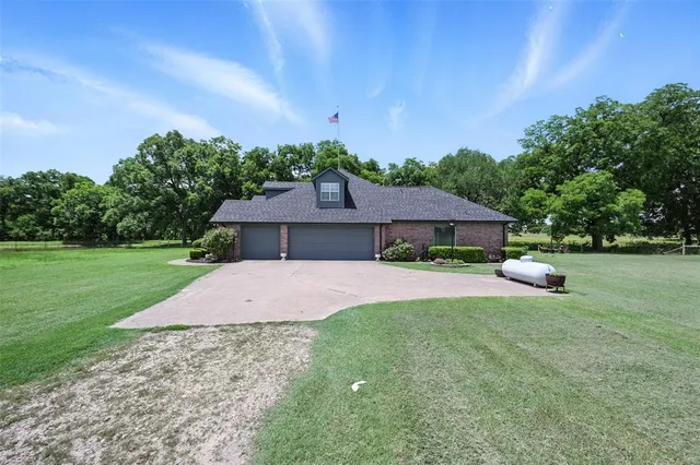 a front view of a house with a garden and yard