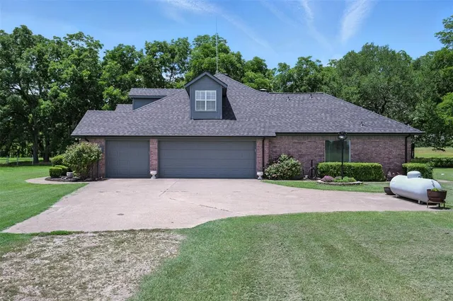 a front view of a house with a garden and yard
