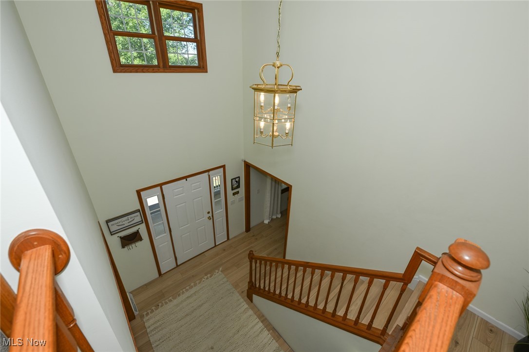 4845 State Road Medina, OH 44256 - Photo 24 of 47 Entryway with wood finished floors, stairway, a towering ceiling, and a chandelier