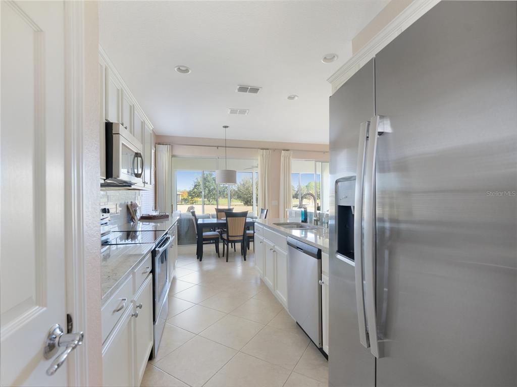 6776 Southwest 91st Circle Ocala, FL 34481 - Photo 31 of 60 a kitchen with stainless steel appliances kitchen island granite countertop a refrigerator and a sink