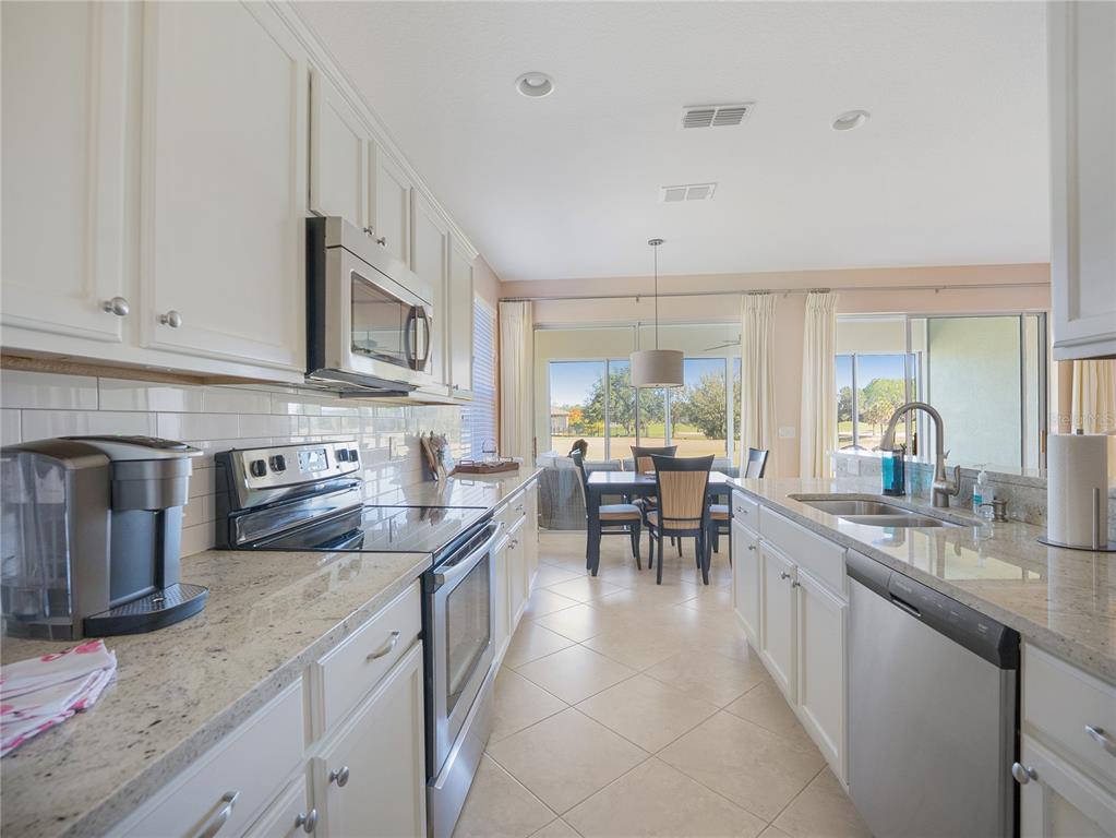 6776 Southwest 91st Circle Ocala, FL 34481 - Photo 32 of 60 a kitchen with stainless steel appliances granite countertop sink microwave and cabinets