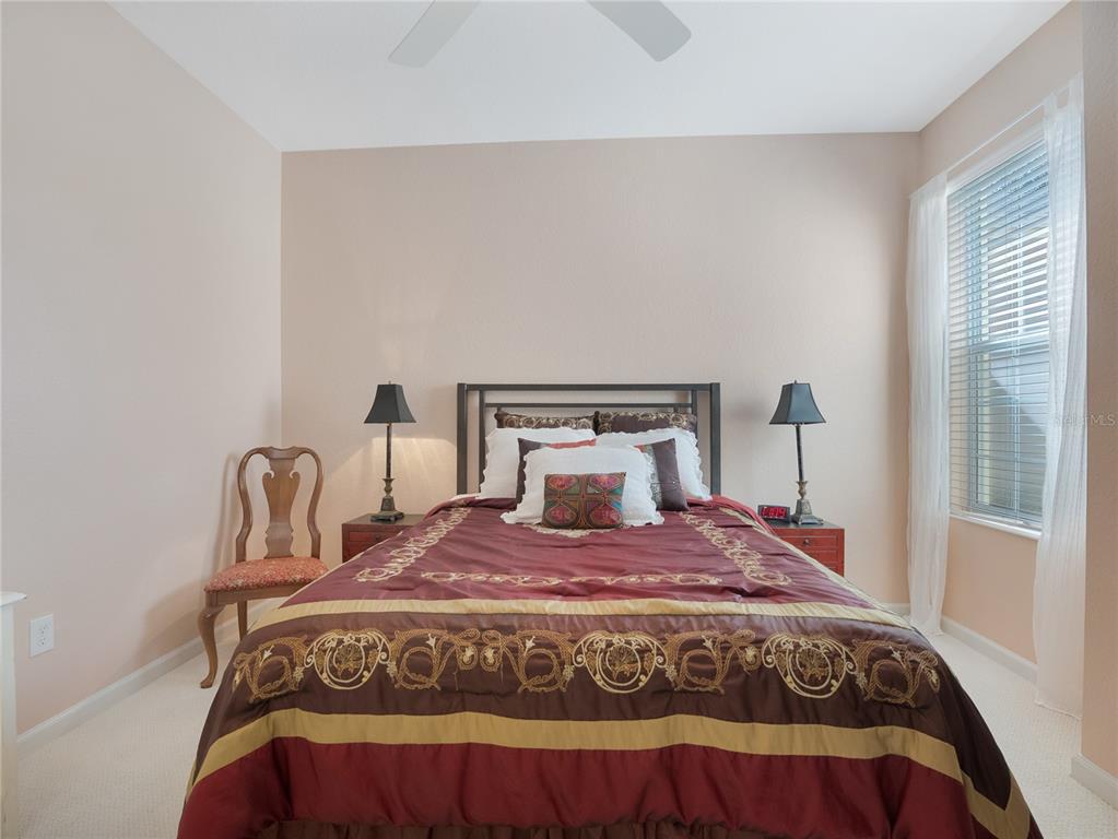 6776 Southwest 91st Circle Ocala, FL 34481 - Photo 44 of 60 a bedroom with a bed a mirror and lamp