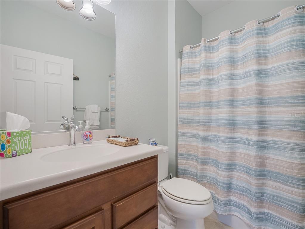 6776 Southwest 91st Circle Ocala, FL 34481 - Photo 46 of 60 a bathroom with a sink a toilet a mirror and shower curtain