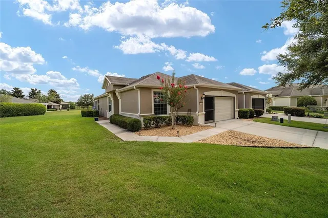 front view of a house with a yard and garage