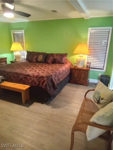 a bedroom with a bed and two windows