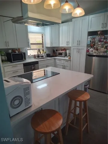 a kitchen with kitchen island a stove a table and chairs in it