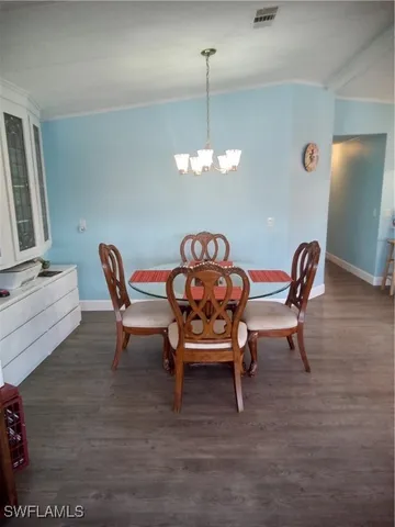 a view of a dining room with furniture and chandelier