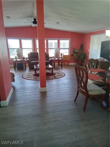 a dining room with furniture water view and a floor to ceiling window