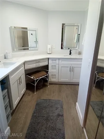a room with a sink a vanity and a mirror