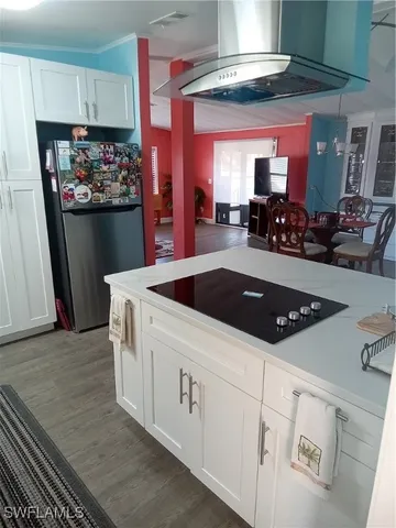 a kitchen with stainless steel appliances a dining table a stove and a refrigerator