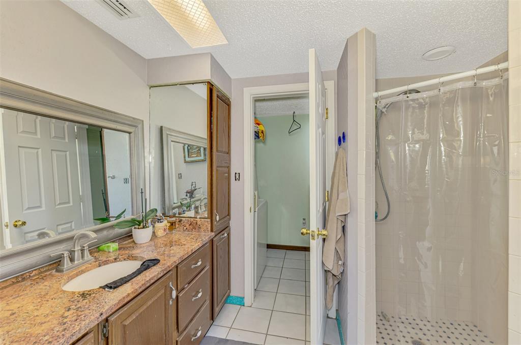 1137 Ponderosa Road Venice, FL 34293 - Photo 27 of 48 a bathroom with a granite countertop sink a mirror and a shower