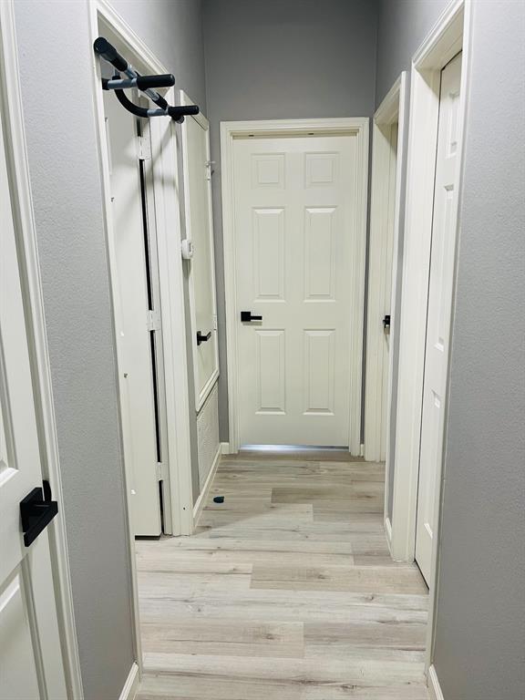 516 Angela Lane Euless, TX 76039 - Photo 26 of 39 Hallway with light wood finished floors and baseboards