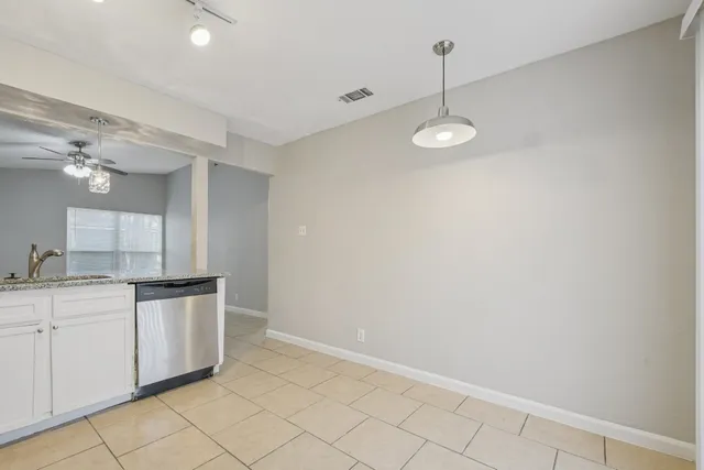 a kitchen with stainless steel appliances granite countertop white cabinets and window