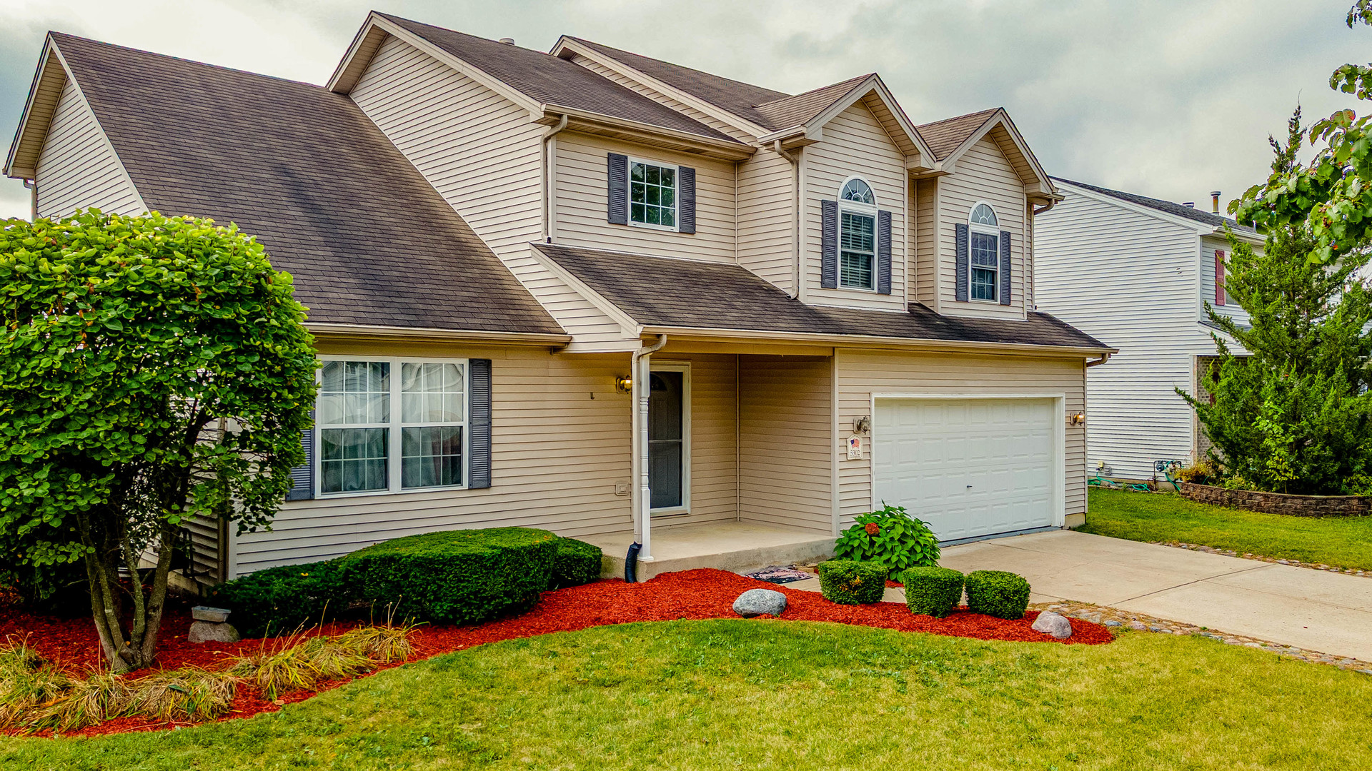 5302 Meadowbrook Street Plainfield, IL 60586 - Photo 2 of 46 a front view of a house with a garden and plants