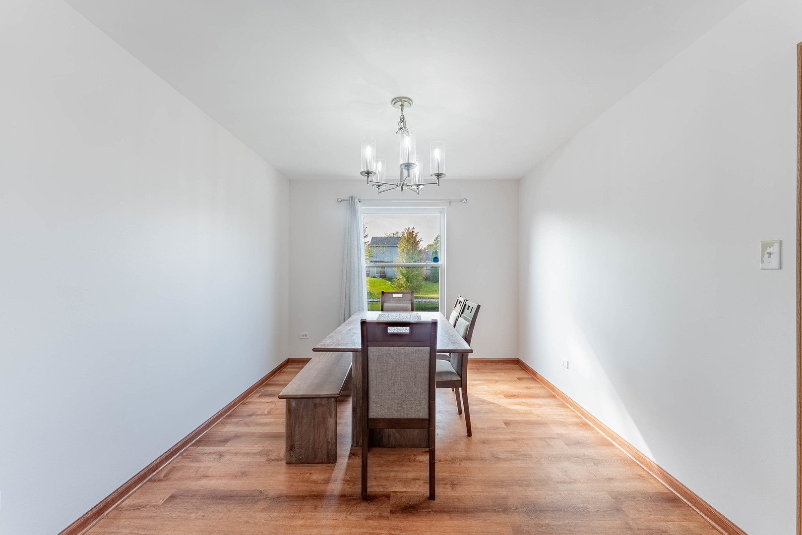 5302 Meadowbrook Street Plainfield, IL 60586 - Photo 9 of 46 a dining room with furniture a chandelier and wooden floor
