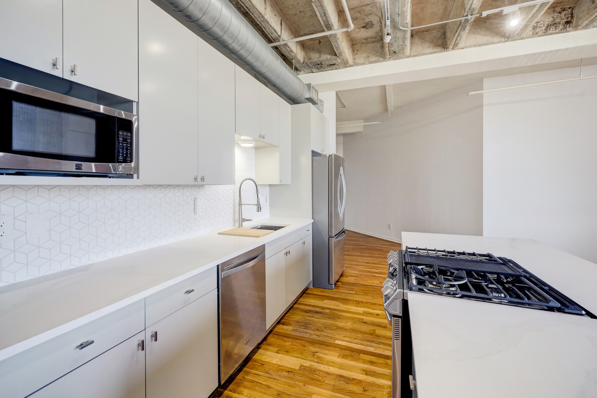 201 Main Street, Unit 6D Houston, TX 77002 - Photo 3 of 24 a kitchen with stainless steel appliances a sink and a microwave