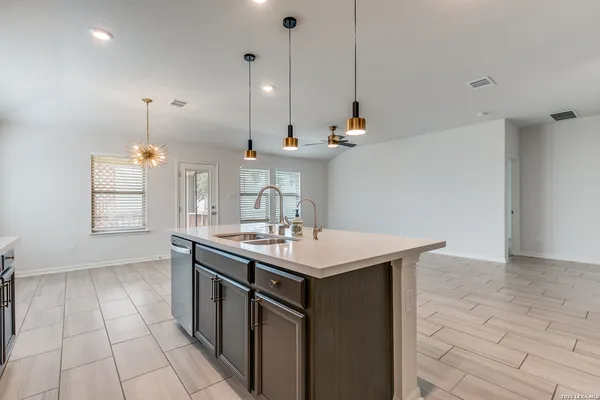 a kitchen with a sink a counter space appliances and cabinets