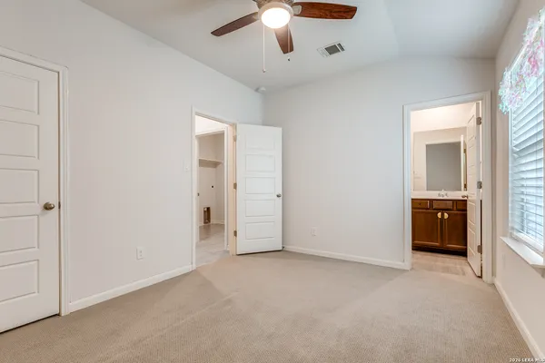 an empty room with closet and a chandelier fan