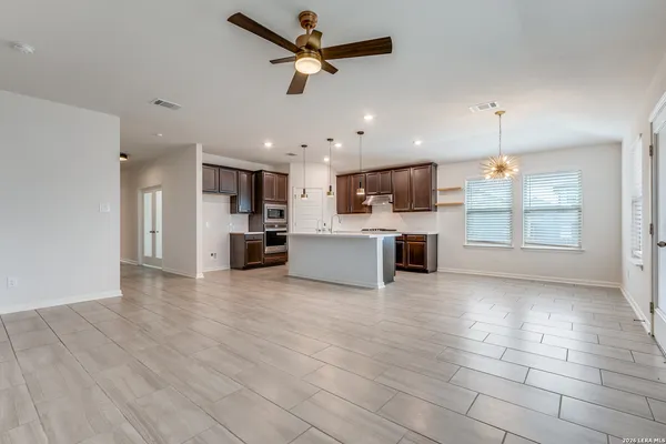 a view of a kitchen with a stove cabinets wooden floor and a ceiling fan