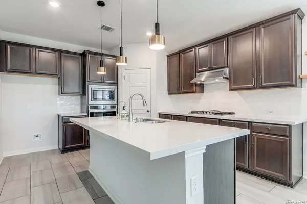 a kitchen with a sink a stove and cabinets