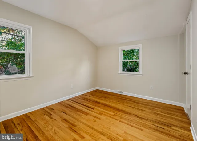 a view of empty room with wooden floor