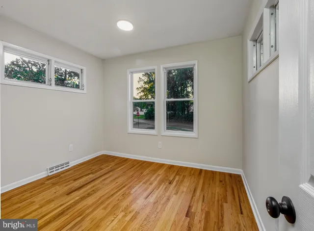 a view of a room with wooden floor and windows