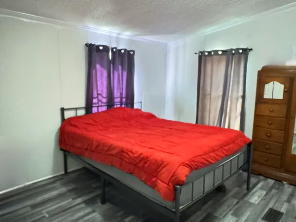 a large bed in a bedroom next to a window