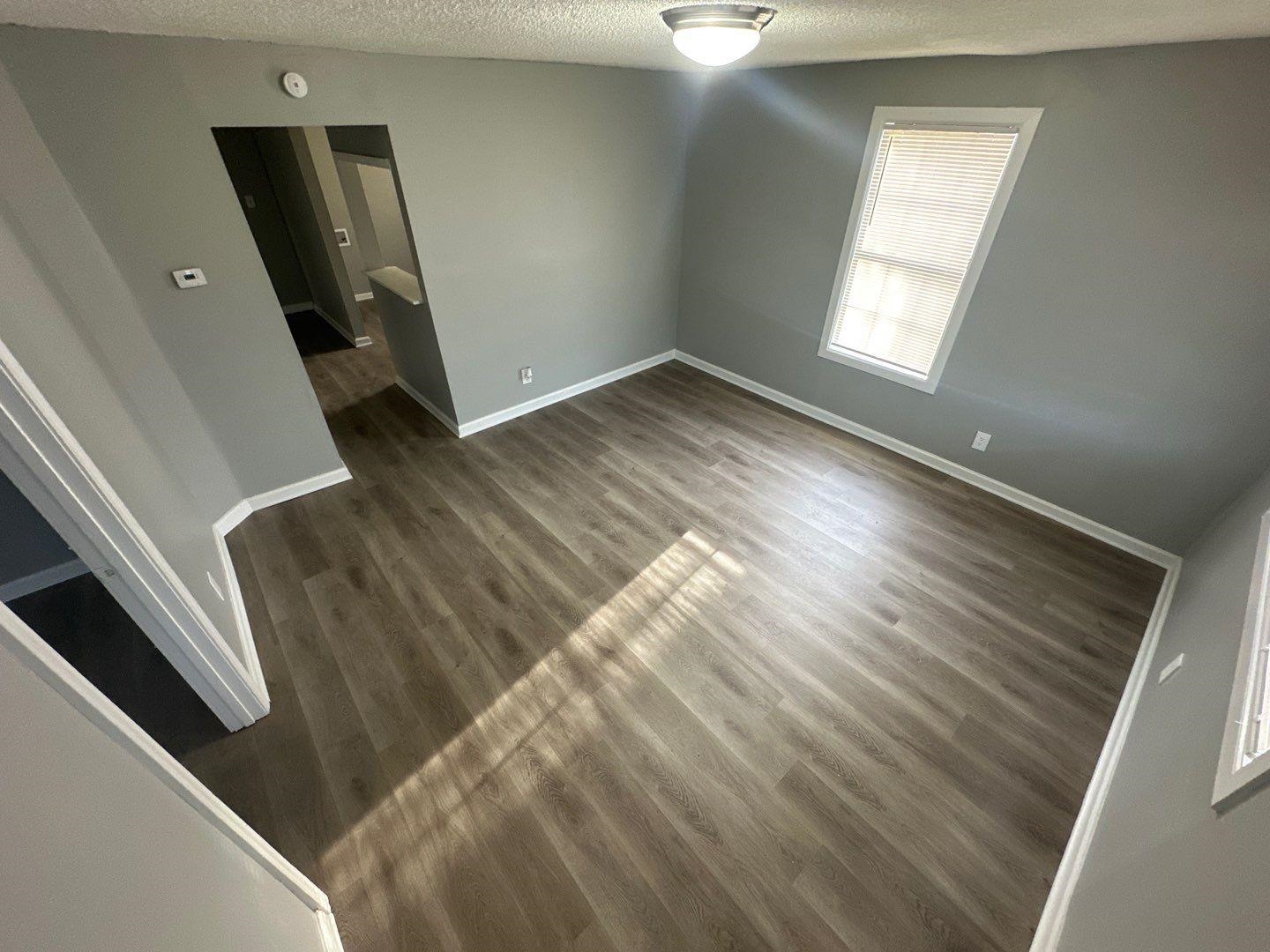 693 Granada Road Memphis, TN 38109 - Photo 2 of 7 a view of an empty room with wooden floor and a window