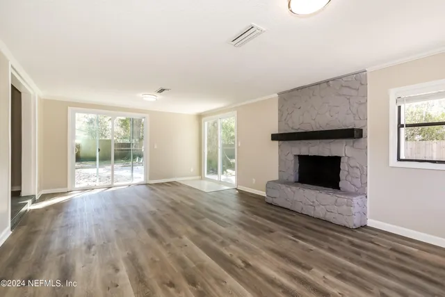 a view of empty room with wooden floor and fireplace