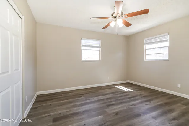 wooden floor in an empty room with a window