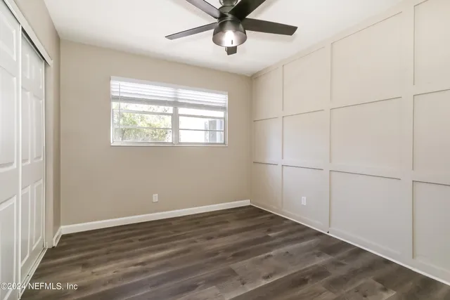 a view of a livingroom with a window and wooden floor