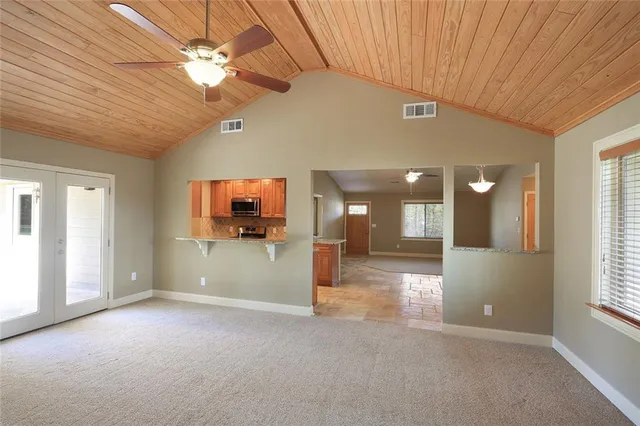 en empty room with windows and ceiling fan