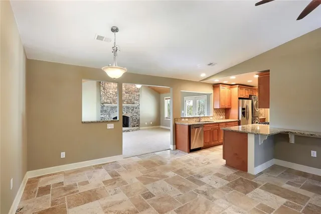 a large kitchen with kitchen island granite countertop a large window and stainless steel appliances